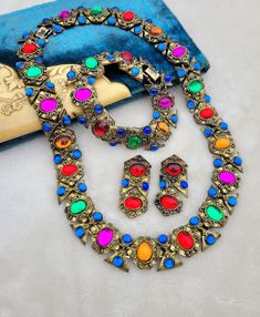 Absolutely gorgeous vibrant gem-toned cabachons set in heavy gold tone metal, with ALL THREE pieces (necklace, earrings, bracelet) of the set still together which is almost unheard of! This set came from an estate and is a classic 1980s-does-1940s style.  This set has sold for up to $400 for just the necklace and earrings, so this is a great deal! All are in good condition, please see pictures for details and measurements.  Thanks for looking! Still Together, Gem Tones, 1940s Style, 1940s Fashion, Necklace And Earrings, Necklace Earrings, Gold Tone Metal, Bracelet Set, Arm Band