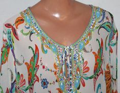 Multicolor V-neck Blouse With Embroidered Neckline, Embellished Multicolor V-neck Tops, Multicolor Beaded Tops For Festival, Multicolor Beaded Bohemian Tops, Multicolor Embroidered Neckline Blouse For Beach, Multicolor Embroidered Neckline Blouse For The Beach, Beach Blouse With Embroidered Neckline In Multicolor, Spring Beaded Multicolor Tops, Tunic Blouse