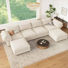 a living room with a large sectional couch and coffee table in the middle of it