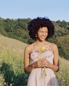 a woman standing in a field with flowers