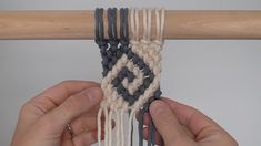 two hands are working on an object with yarn