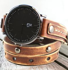 Beautiful rustic leather wrap around watch, hand dyed with brown. Distressed accents add a weathered, timeworn look creating a rustic and casual feel to these otherwise elegant pieces.  Black watch face, gunmetal rivets and off white color hand stitching complete the design. The wrap watch is made with veg tanned leather, completely handmade, hand stitched with natural thread and dyed with eco stain.   Wrap style bands will fit for all wrist sizes. The entire length of the watch is 27.5 inches a Rugged Brown Leather Watches, Rugged Leather Strap Watch Accessories, Vintage Brown Adjustable Watch Band, Rugged Brown Waxed Watch Band, Rugged Brown Waxed Finish Watch Bands, Vintage Brown Watches With Leather Strap, Vintage Brown Watch With Leather Strap, Vintage Brown Watch With Leather Strap Accessories, Everyday Brown Watch With Waxed Finish