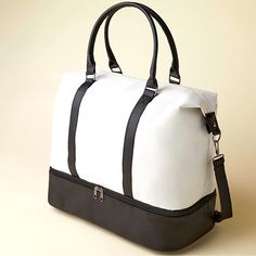 a white and black duffel bag sitting on top of a table