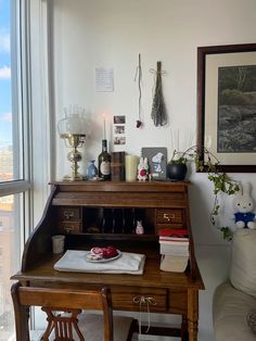 a room with a large window and a desk in front of it, next to a couch