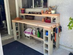 the outside of a house with pots and other items on it's shelfs