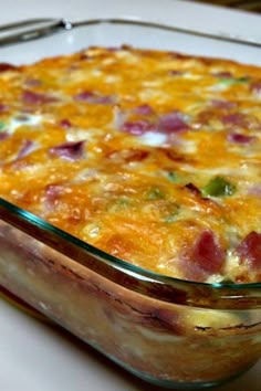 a casserole dish with ham and cheese in it on a white plate next to a fork