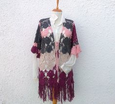 a woman's cardigan with crocheted flowers and fringes on it