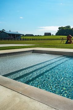 an empty swimming pool in the middle of a field