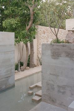 an outdoor pool with steps leading up to it and trees in the back ground area