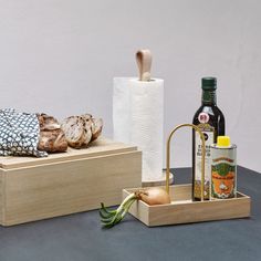 some bread and other food items are sitting on a table next to a roll dispenser