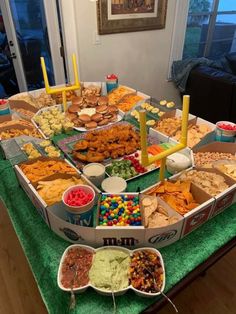 a table filled with lots of food on top of a green cloth covered tablecloth