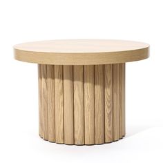 a round wooden table sitting on top of a white floor