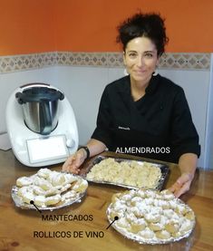 a woman sitting at a table in front of two pies and an air fryer