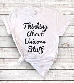 This "Thinking About Unicorn Stuff" design is the perfect shirt for anyone that loves to daydream about all things unicorns! Unicorn Shirt Ideas, Unicorn Tee Shirt, Ugly Christmas Sweater Couples, Cute White T-shirt With Unicorn Print, Fun Unicorn Print T-shirt For Summer, Cute Unicorn Print Crew Neck T-shirt, Finishing School, Christmas Sweater Party, Affordable White T-shirt With Unicorn Print