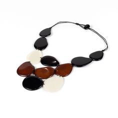 Elevate your style with this Chunky Tagua Nut Necklace, a bold and beautiful statement piece that blends sustainability with bohemian flair. Each necklace is handcrafted from Tagua nuts, known as "vegetable ivory," sourced responsibly from the lush rainforests of South America. This unique material is not only eco-friendly but also incredibly lightweight, making it comfortable for all-day wear. The necklace features large, chunky beads that create a stunning visual impact, perfect for adding a p Black Artisan Necklaces For Beach, Black Artisan Necklace For Beach, Artisan Black Necklace For Beach, Brown Necklaces With Black Beads For Beach, Black Wooden Beads Necklace For Beach, Black Necklaces With Large Beads For Beach, Black Bohemian Necklace For Beach, Bohemian Black Necklace For Beach, Bohemian Bib Necklaces With Large Beads