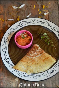 a plate with some food on it and a small bowl of salsa in the middle