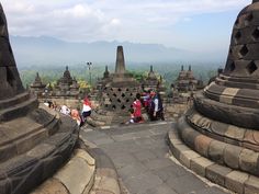 people are standing on top of an ancient structure with mountains in the backgroud