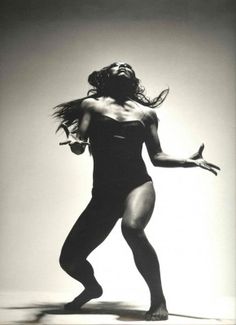 a black and white photo of a woman in a bathing suit with her arms outstretched