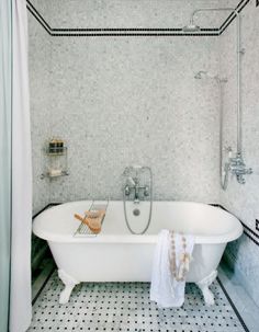 a white bath tub sitting next to a shower