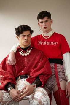 two men in red shirts and white lace garters sitting next to each other