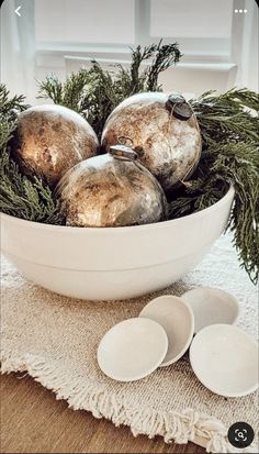 a white bowl filled with ornaments on top of a table