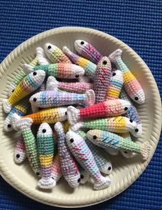 small knitted fish on a white plate with blue table cloth in the back ground