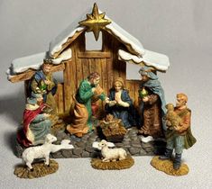 a nativity scene with figurines of people and animals in front of a stable