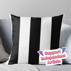 a black and white striped pillow with the words support independent artists in pink on it