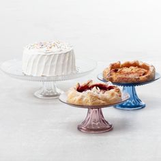 three different types of cakes on glass plates