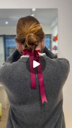 a woman wearing a gray sweatshirt with a pink ribbon around her neck and back view