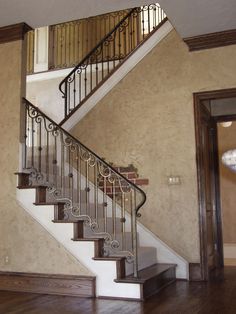 a stair case in an empty room with wood floors