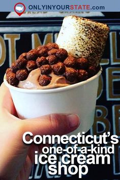 someone is holding up a cup with ice cream and nuts in it that says connectit's one - of - a - kind ice cream shop