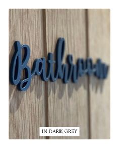 the word bathhouse in dark grey on a wooden wall