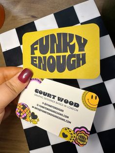 a person holding up a business card with the words funky enough written on it in black and yellow