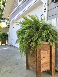 a wooden planter sitting on the side of a house