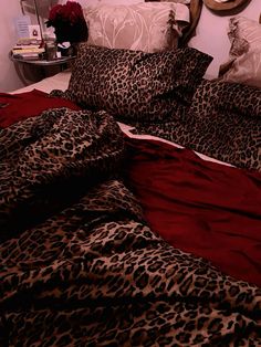 a leopard print comforter on a bed with red sheets