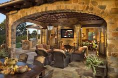 an outdoor living area with stone walls and furniture