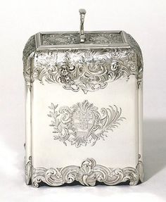 an ornately decorated silver box with a water faucet on the top and sides