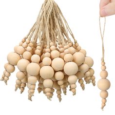 a bunch of wooden beads hanging from a string next to a person's hand