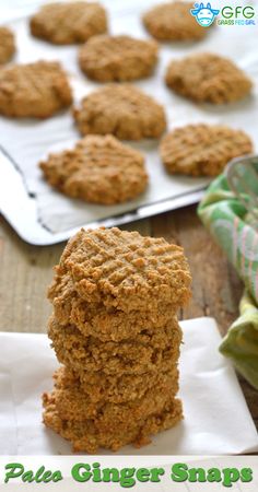 a stack of cookies sitting on top of a paper towel next to a cookie sheet