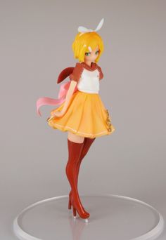 a figurine is posed on a round base with an orange skirt and white top