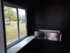 an empty window sill in the corner of a room with black walls and cabinets