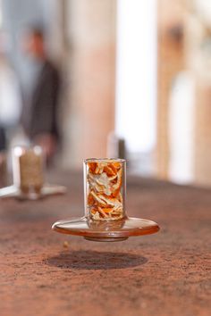 a glass filled with liquid sitting on top of a table