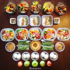 several plastic containers filled with food on top of a wooden table next to green apples