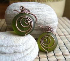 two green earrings sitting on top of white rocks