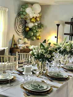 a table set with plates and silverware for a formal dinner or party, surrounded by balloons