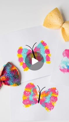 three butterfly crafts are shown on top of paper and one is made with colored crayons