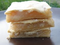 three pieces of cake sitting on top of a metal plate with grass in the background