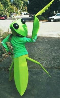 a woman dressed as a grasshopper holding an umbrella