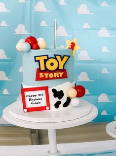 a toy story themed birthday cake on a table with clouds and blue sky in the background